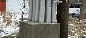 Aerial electrical and telecommunication utilities were relocated underground throughout portions of the south end. Crews installing underground electrical and telecommunication duct bank. This shows the concrete riser that houses the underground conduits at its terminus on Briggs Street.