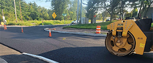 Paving the binder course at the intersection of Queen City Park Road and Austin Drive.