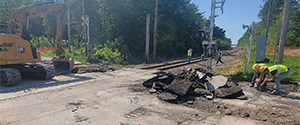 The removal of the asphalt at the Home Avenue railroad crossing in preparation for the installation of precast concrete panels and small box culverts.